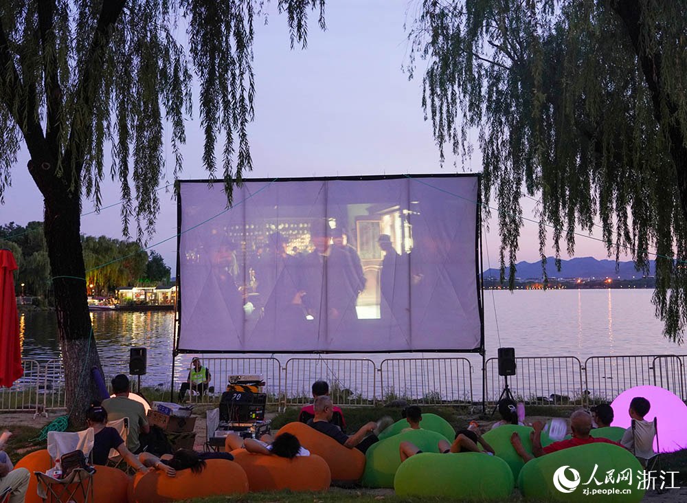 8月8日，市民在浙江紹興柯橋瓜渚湖畔觀影。人民網 章勇濤攝