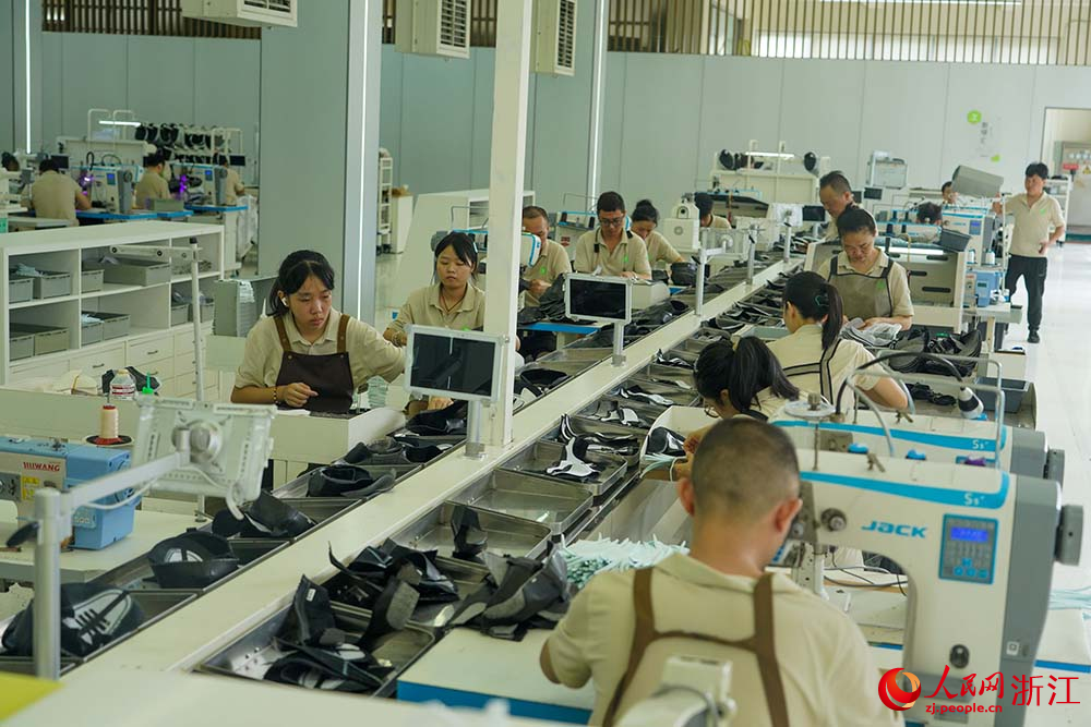 浙江省溫州市鹿城區的鞋企生產車間，工人在生產線上趕制訂單。人民網 章勇濤攝