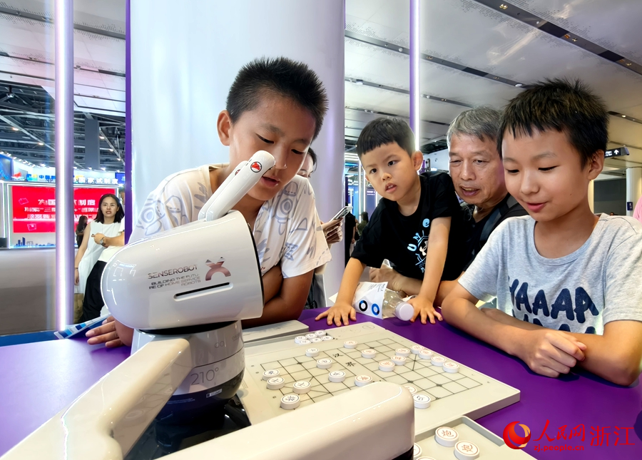 五年級的學生候晉凱正同機器人一較棋藝。人民網記者 張麗瑋攝