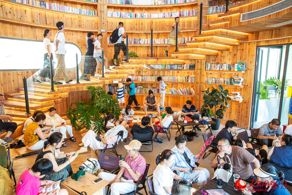 10月7日，浙江省溫州市蒼南縣金鄉鎮石砰碼頭，由擁有數十年歷史的老油庫改造而成的咖啡館內，游客們喝咖啡、品書香、賞海景，盡享假日休閑時光。人民網記者 葉賓得攝