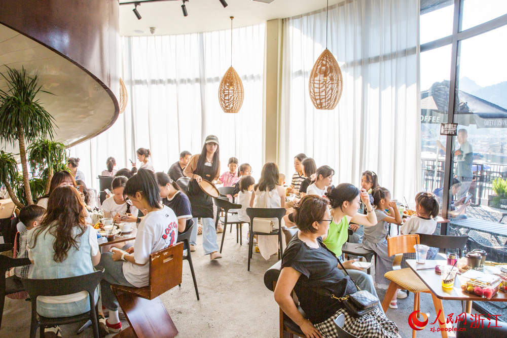 10月7日，浙江省溫州市蒼南縣金鄉鎮石砰碼頭，由擁有數十年歷史的老油庫改造而成的咖啡館內，游客們喝咖啡、品書香、賞海景，盡享假日休閑時光。人民網記者 葉賓得攝