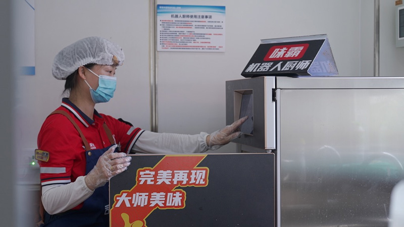 工作人員操作炒菜機器人烹飪菜品。中國石化浙江石油分公司供圖